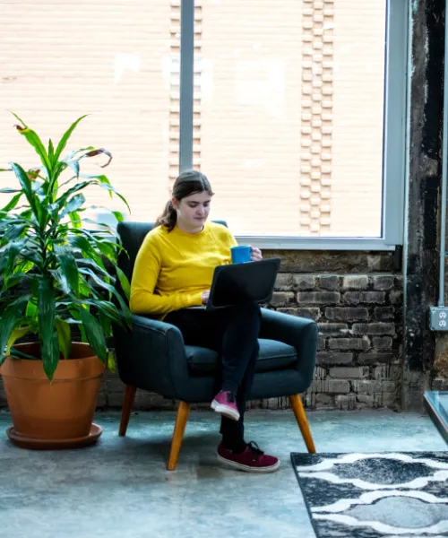 Shannon Seguin of Click Control Marketing working on a laptop with coffee in hand.