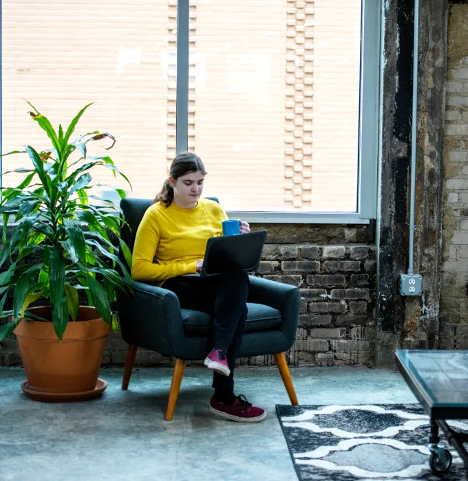 Shannon Seguin of Click Control Marketing working on a laptop with coffee in hand.